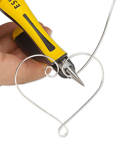 Pliers looping wire into a heart shape